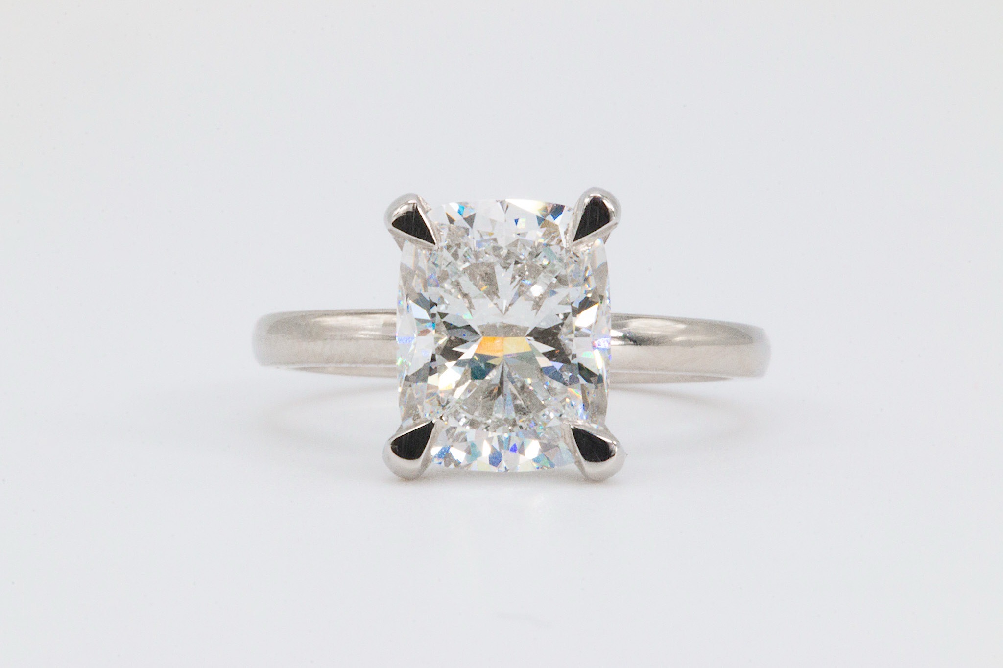A silver ring with a large, square-cut clear gemstone set in a four-prong setting, against a plain white background.