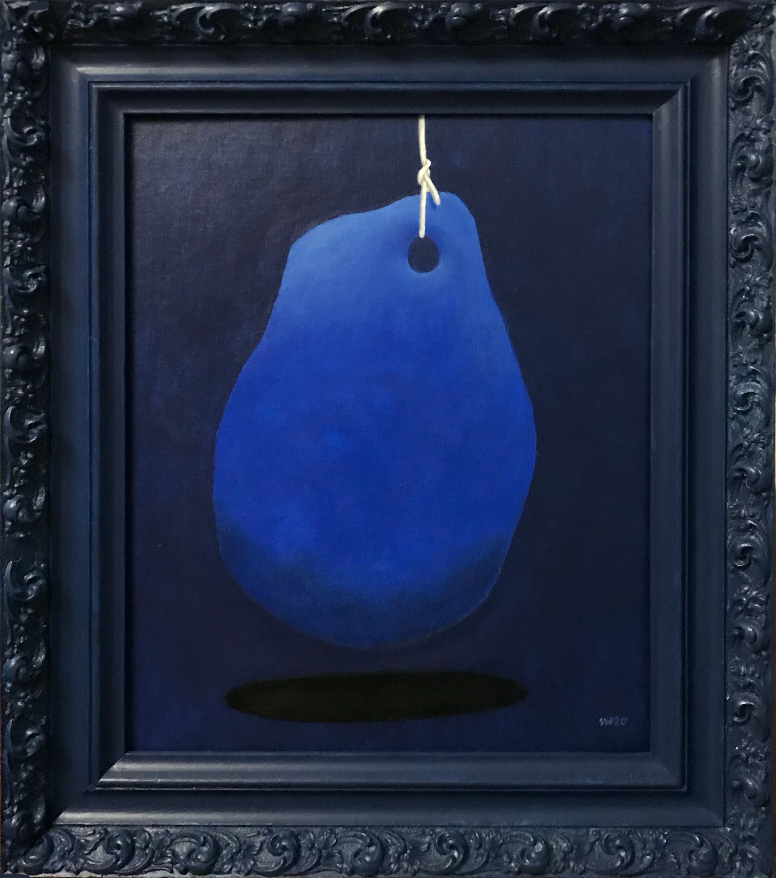Blue abstract shape hanging from a string, with a dark shadow below, in a black ornate frame.